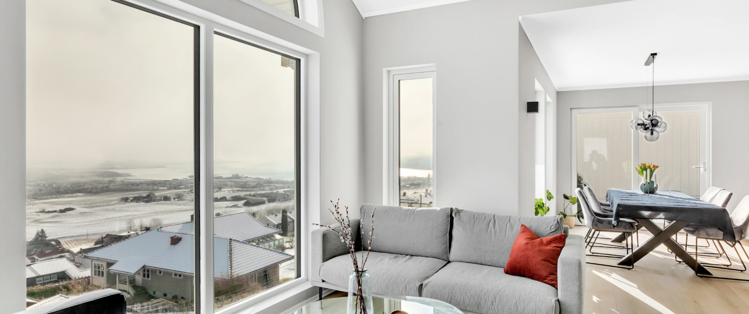Lys og moderne stue med store vindusflater og buet vindu